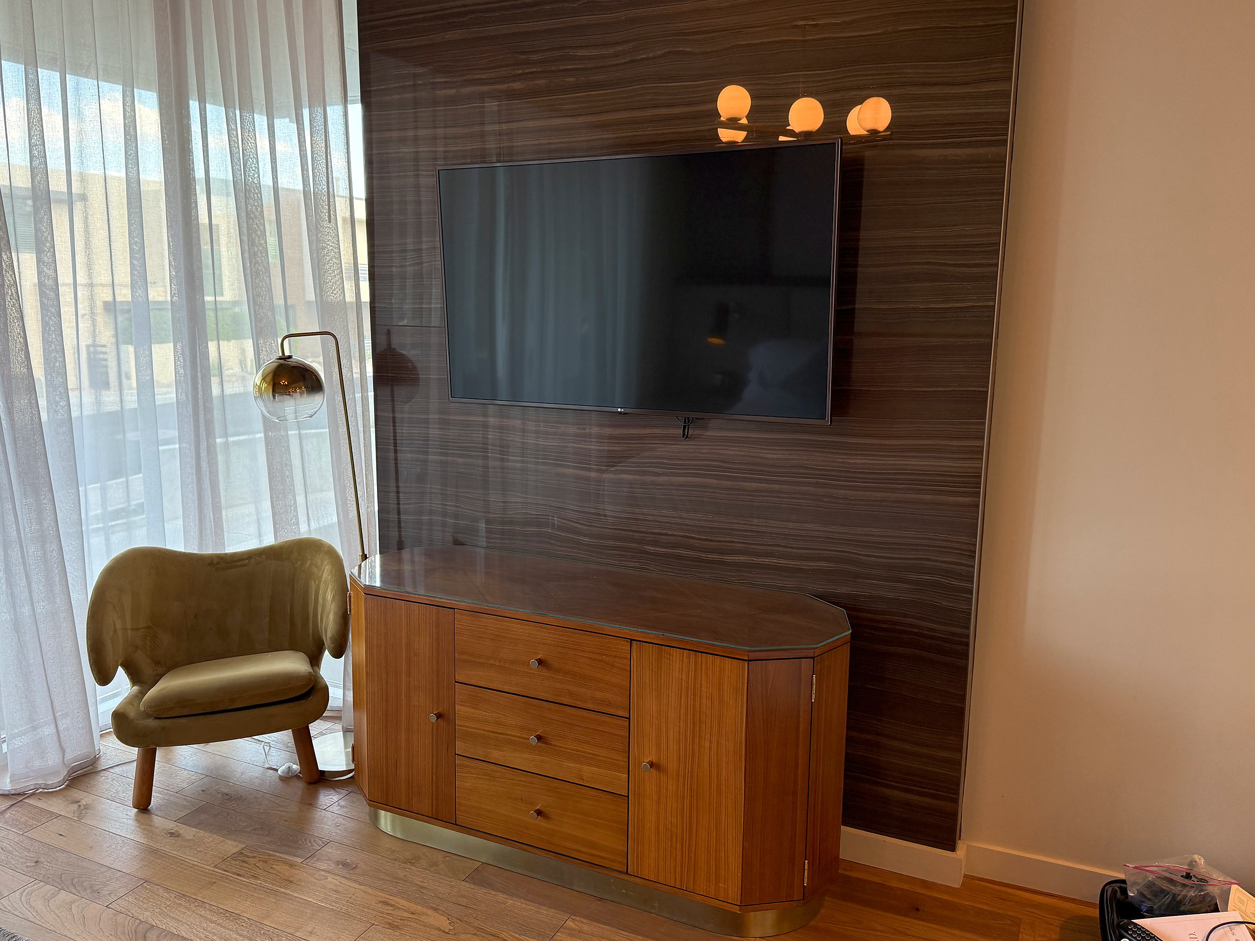Credenza, television and lounge chair on the walnut wall