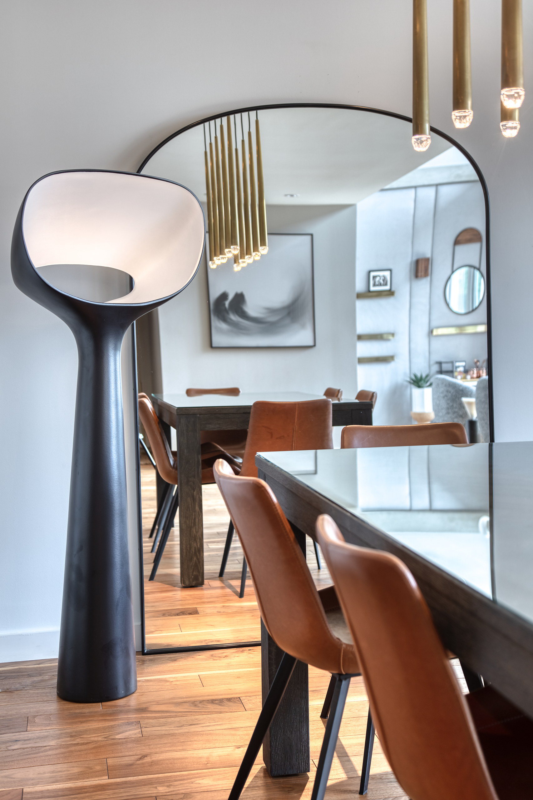 Dining table with leather chairs, floor lamp and arched mirror