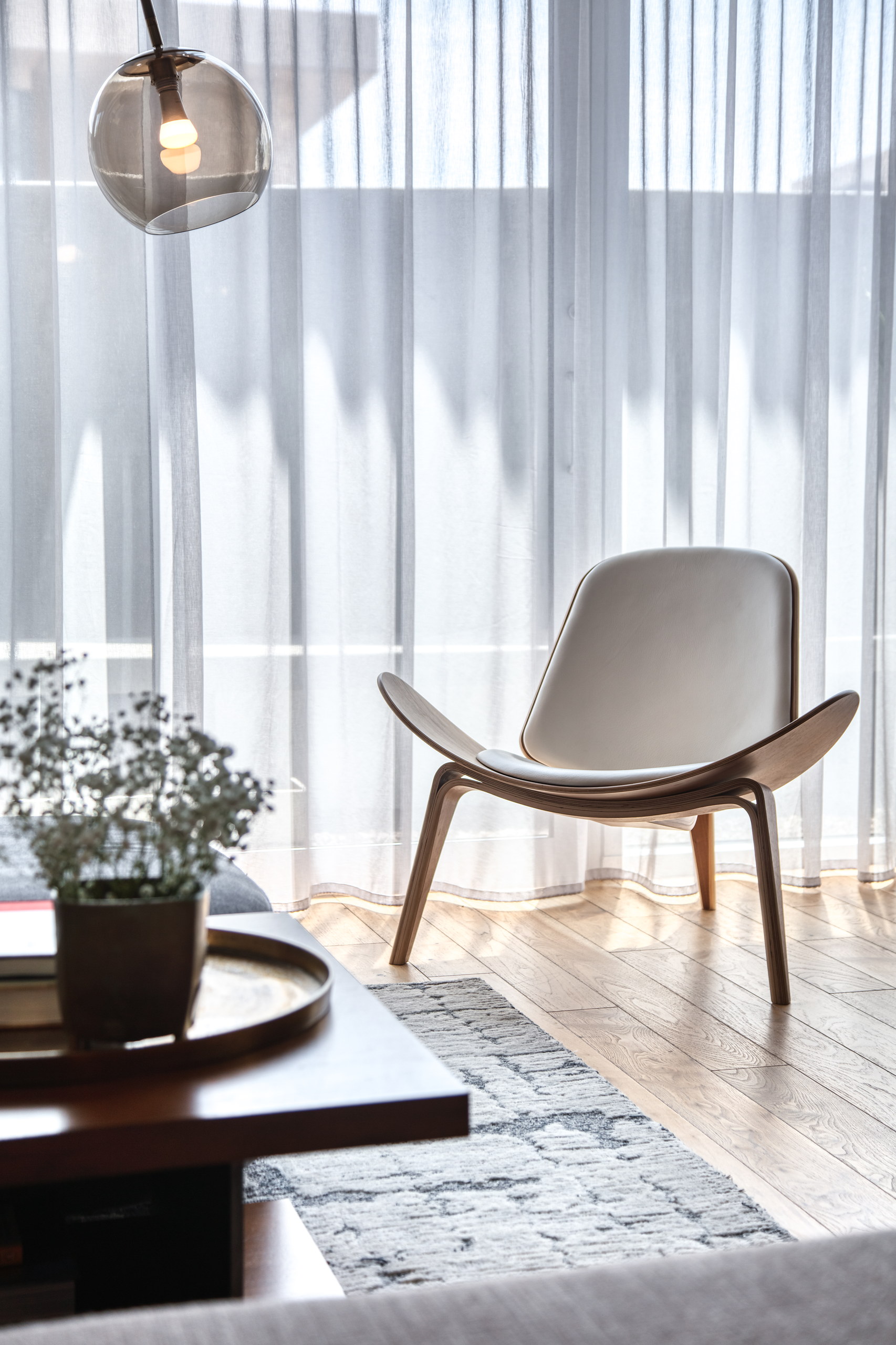 Three-legged shell lounge chair at the window